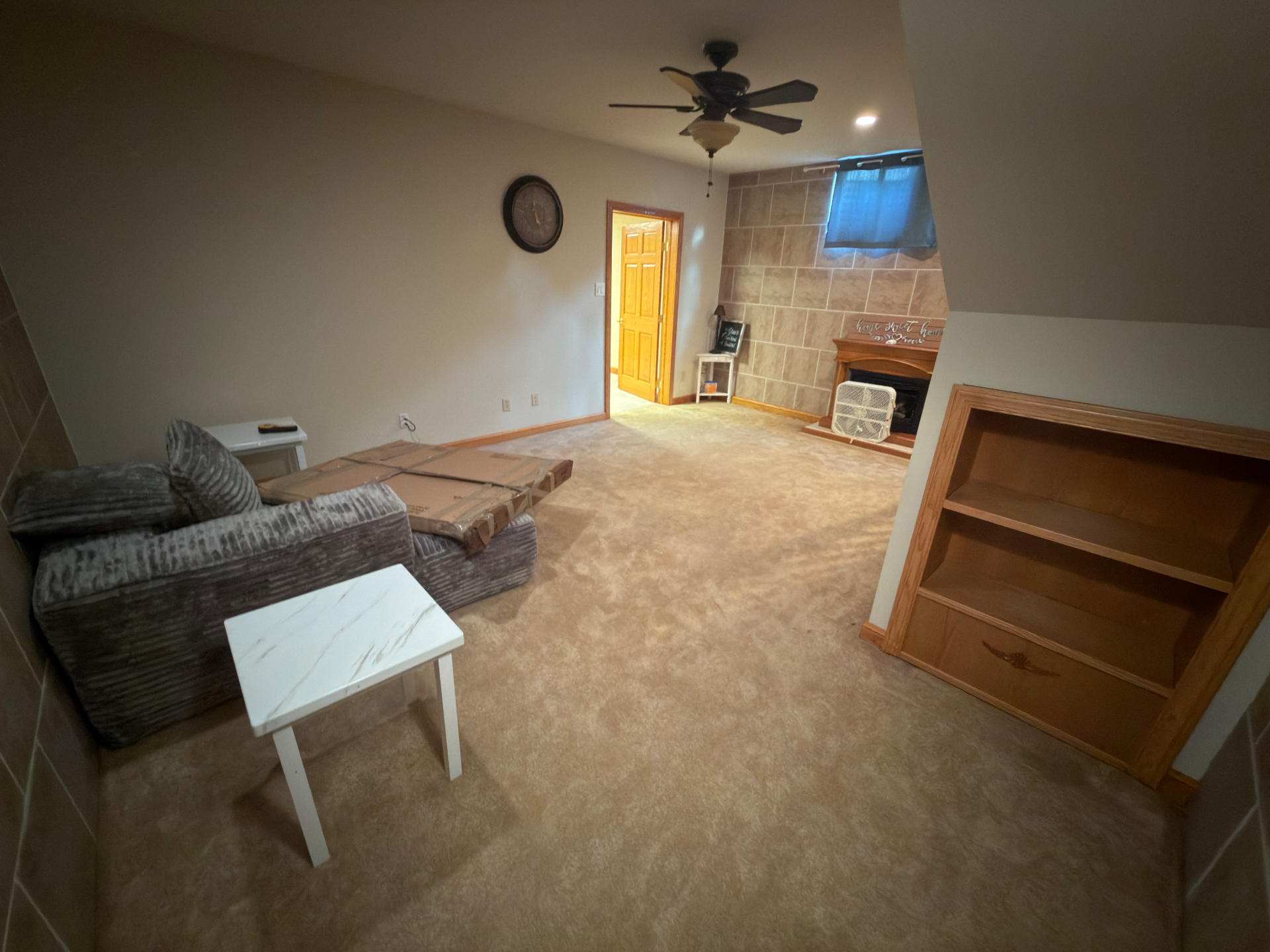 Finished basement living area with wet carpet before removal after a hot water tank burst in Central Ohio