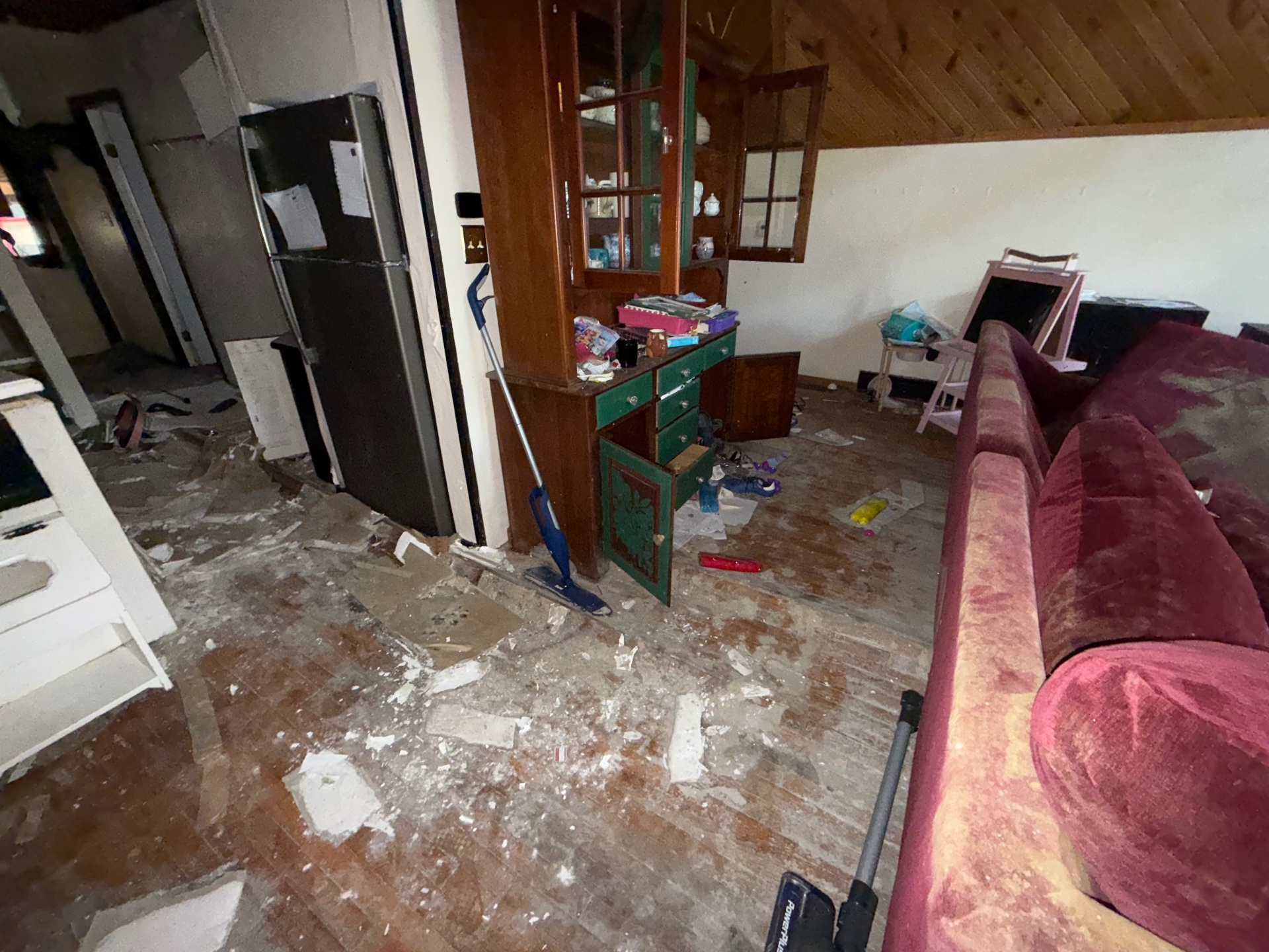 Living area during water-damage debris removal and floor cleanup by Franks Local Services LLC