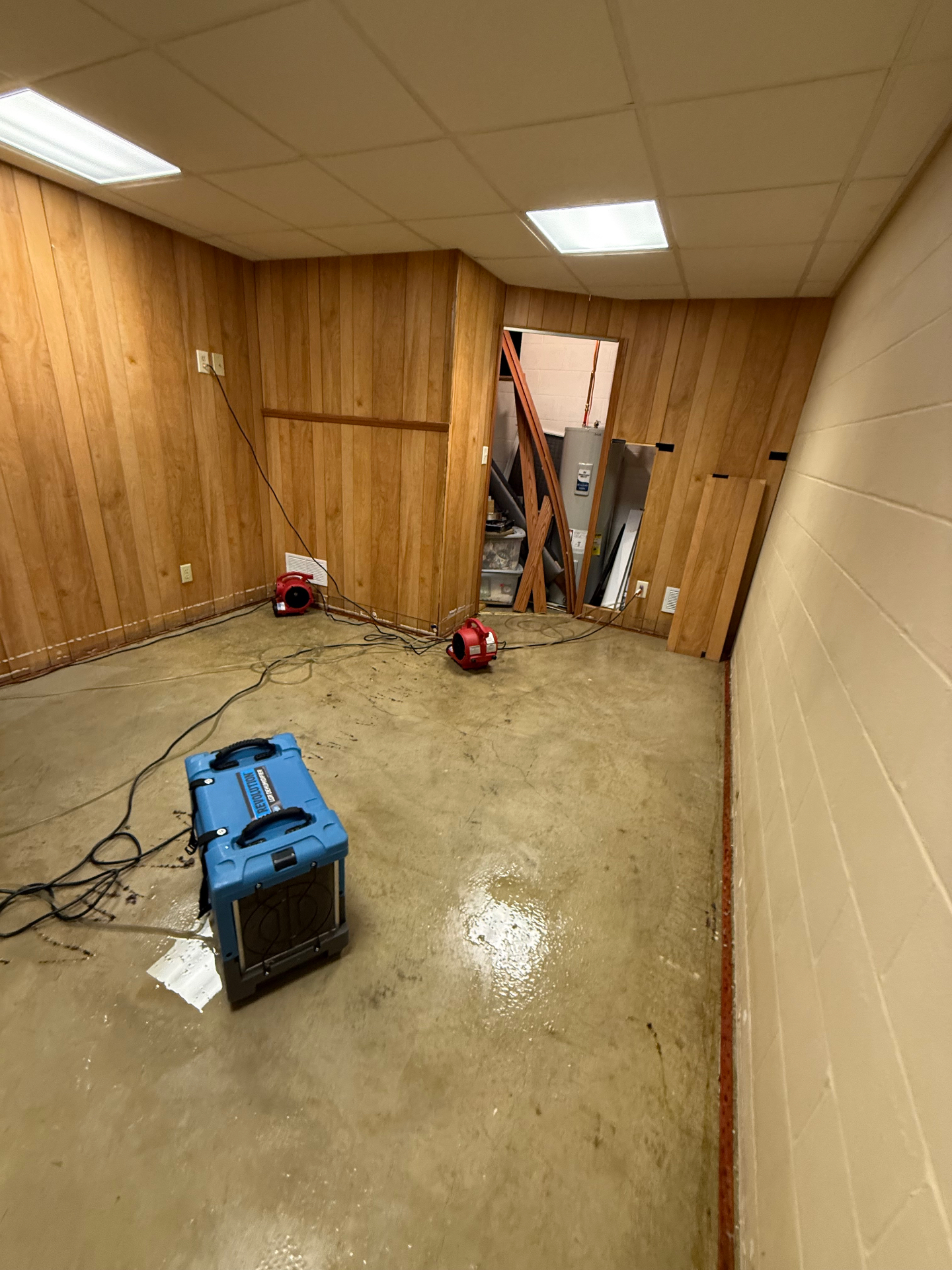 Professional drying equipment in a flooded basement after a hot water tank burst