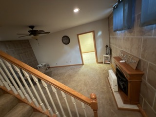 Carpeted basement with fireplace before wet flooring removal after a burst hot water tank